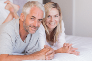 smiling man and woman in bed