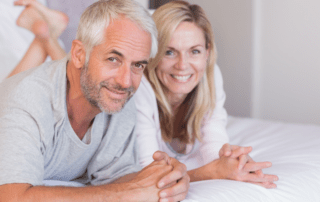 smiling man and woman in bed